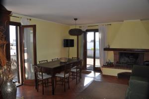 塔维亚诺Corte degli Aranci Casa Vacanze的一间带桌椅和壁炉的用餐室
