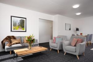 墨尔本Aligned Corporate Residences Kew的客厅配有沙发、两把椅子和一张桌子