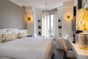 巴黎班维勒酒店的卧室配有一张白色大床和一张书桌