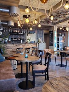 马尔默哈弗舒特莱特酒店的一间带桌椅的餐厅和一间酒吧