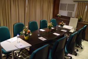 钦奈Thiviyam Airport Hotel的一间会议室,配有长桌子和椅子