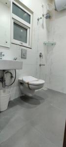 海得拉巴SwanSuites Gachibowli的白色的浴室设有卫生间和水槽。
