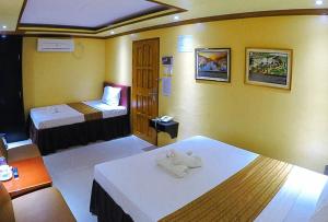 土格加劳RedDoorz Plus @ Taj Hotel Tuguegarao的酒店客房 - 带两张床和毛巾