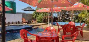 蓬塔杜欧鲁MOZBEVOK Coconut View Resort的一个带红色桌椅的庭院和一个游泳池