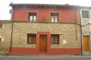 LazagurríaCasa Parra Lazagurria的街上有橙色门的石头建筑