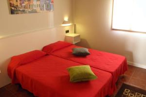 LazagurríaCasa rural, 15 personas, 7 habitaciones,gran salón的一间卧室配有红色的床和两个枕头