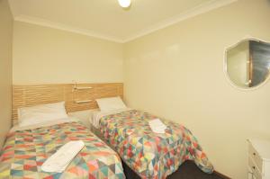 肯图巴卡通巴城镇酒店的客房设有两张床和一台墙上的电视。