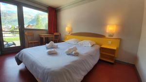 瓦勒迪泽尔Village vacances de Val d'Isère的酒店客房,配有带毛巾的床