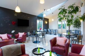 梅朗格勒诺布尔梅兰舒适酒店的一间带桌椅的餐厅以及墙上的电视