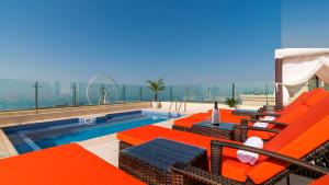迪拜Dubai Jbr Amazing Penthouse With Stunning View的一个带橙色躺椅的游泳池和一个游泳池