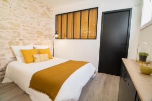 尼姆Appartement Cosy Nîmes-Centre的一间卧室配有一张带黄色枕头的大床