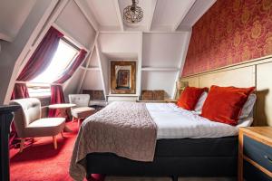 Vuren斯万酒店的一间卧室配有一张带红色枕头的大床