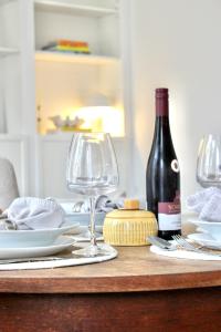 SpirkelbachApartment Rose的一张桌子,上面放着一瓶葡萄酒和两杯酒杯