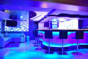 钦奈Thiviyam Airport Hotel的一间酒吧,在一间紫色和蓝色的灯光房间内