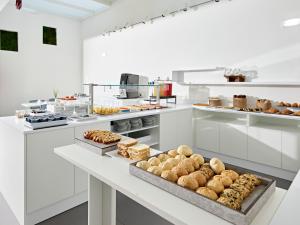 利尼亚诺萨比亚多罗Art Hotel Principe的一间白色的大厨房,提供多种不同类型的糕点