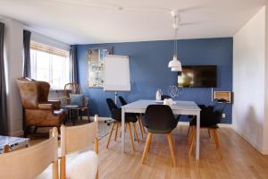 勒兹维Kridthuset的一间拥有蓝色墙壁和桌椅的用餐室