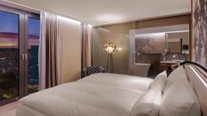 罗拉赫Hotel Stadt Lörrach的卧室设有一张白色大床和一扇窗户。