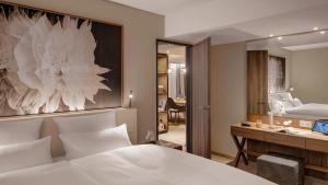 罗拉赫Hotel Stadt Lörrach的一间卧室配有一张床、一张书桌和一面镜子