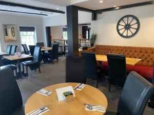 利明顿The New Wheel Inn的餐厅设有桌椅和沙发。