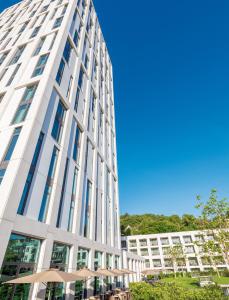 罗拉赫Hotel Stadt Lörrach的一座高大的白色建筑,设有玻璃窗