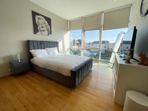 格拉斯哥City Centre 2-Bed Apartment Parking Jacuzzi Bath的一间卧室设有一张床和一个大窗户