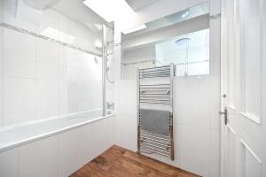 伦敦Soho, Piccadilly & Chinatown - Two Bedroom & Two Double Beds Apartment的白色的浴室设有浴缸和淋浴。