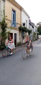 丰特夫罗拉拜L'arbrissel的两个穿衣的女人骑着自行车沿着街道走