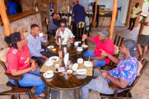 AkageraAkagera Transit Lodge的一群坐在餐厅桌子上的人