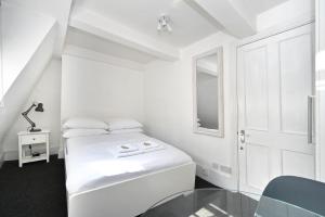 伦敦Soho, Piccadilly & Chinatown - Two Bedroom & Two Double Beds Apartment的白色的卧室设有床和窗户