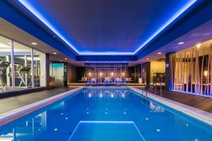 罗加斯卡斯拉提纳Hotel Aleksander Medical & SPA的蓝色灯光的酒店游泳池