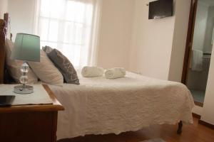 科英布拉Gouveia Residence的一间卧室配有一张带灯和镜子的床