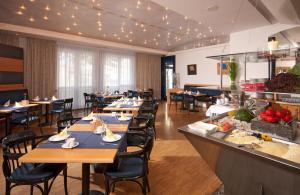腓特烈港希霍泰尔腓特烈港酒店的一间带桌椅的餐厅以及一间自助餐