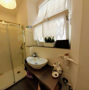 安科纳Il Balcone Sul Corso的一间带水槽和玻璃淋浴的浴室
