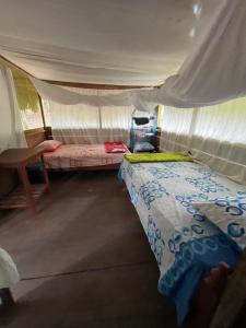 塔拉波托Katari Center的一间帐篷内带两张床的卧室
