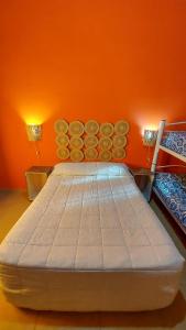 卡法亚特Casa en Cafayate的一张位于橙色墙壁的大床