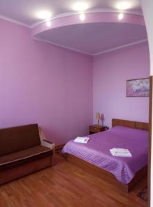 HryshkivtsiГотель "У Свата" Гришківці Бердичівський р-н的紫色卧室配有一张床和一张沙发