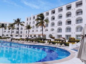 曼萨尼约Sierra Mar All Inclusive at Tesoro Manzanillo的大楼前设有大型游泳池的酒店