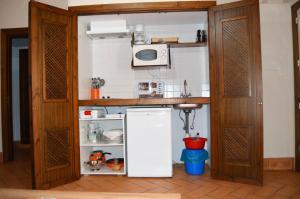 AlisedaApartamentos Turísticos - Hostal Los Alisos的小厨房配有冰箱和微波炉。
