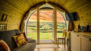 阿伯里斯特威斯Forester's Retreat Glamping - Cambrian Mountains View的客厅设有大型拱形窗户,享有美景。