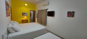 里约布兰科Recanto na Floresta的卧室配有白色的床和黄色的墙壁