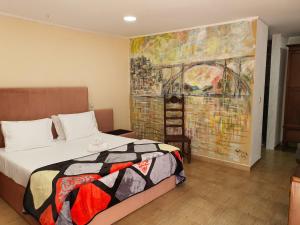 阿马马尔Gojim Casa Rural的卧室配有一张床,墙上挂有绘画作品