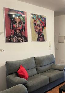 拉桑塔Apartamento las quemadas的客厅配有沙发和墙上的两幅画作