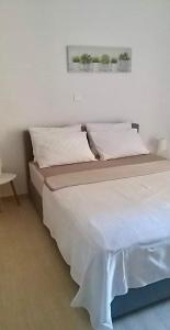 阿特米达Marina Apartment的一张带白色床单和枕头的床