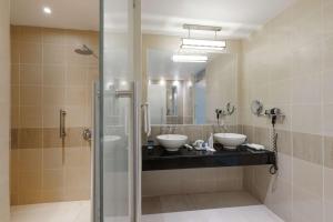 拉各斯安克雷奇丽笙酒店的一间带两个盥洗盆和淋浴的浴室