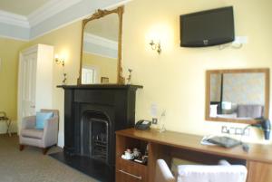 爱丁堡索尔兹伯里酒店的客房设有壁炉、书桌和镜子