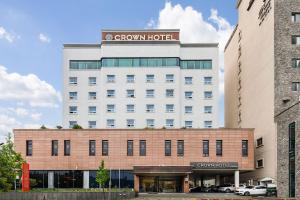 昌原市Crown Hotel Changwon的一座白色的大建筑,带有棕色的酒店