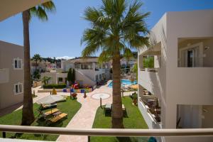 普拉塔尼亚斯Toxo Hotel的享有棕榈树庭院和游泳池的景色