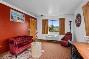 南旧金山阿美莉卡那汽车旅馆的客厅配有红色的沙发和桌子