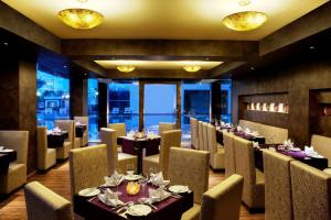 Dhāruhera比瓦迪金色郁金香酒店的用餐室设有桌椅和窗户。