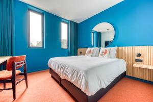 Saint-GhislainMah Hotel的一间蓝色卧室,配有床、桌子和镜子